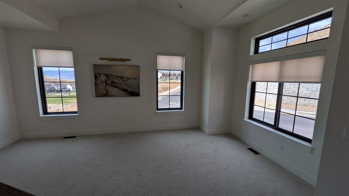 Light-filtering motorized roller shades on three windows in a Lehi, Utah custom home
